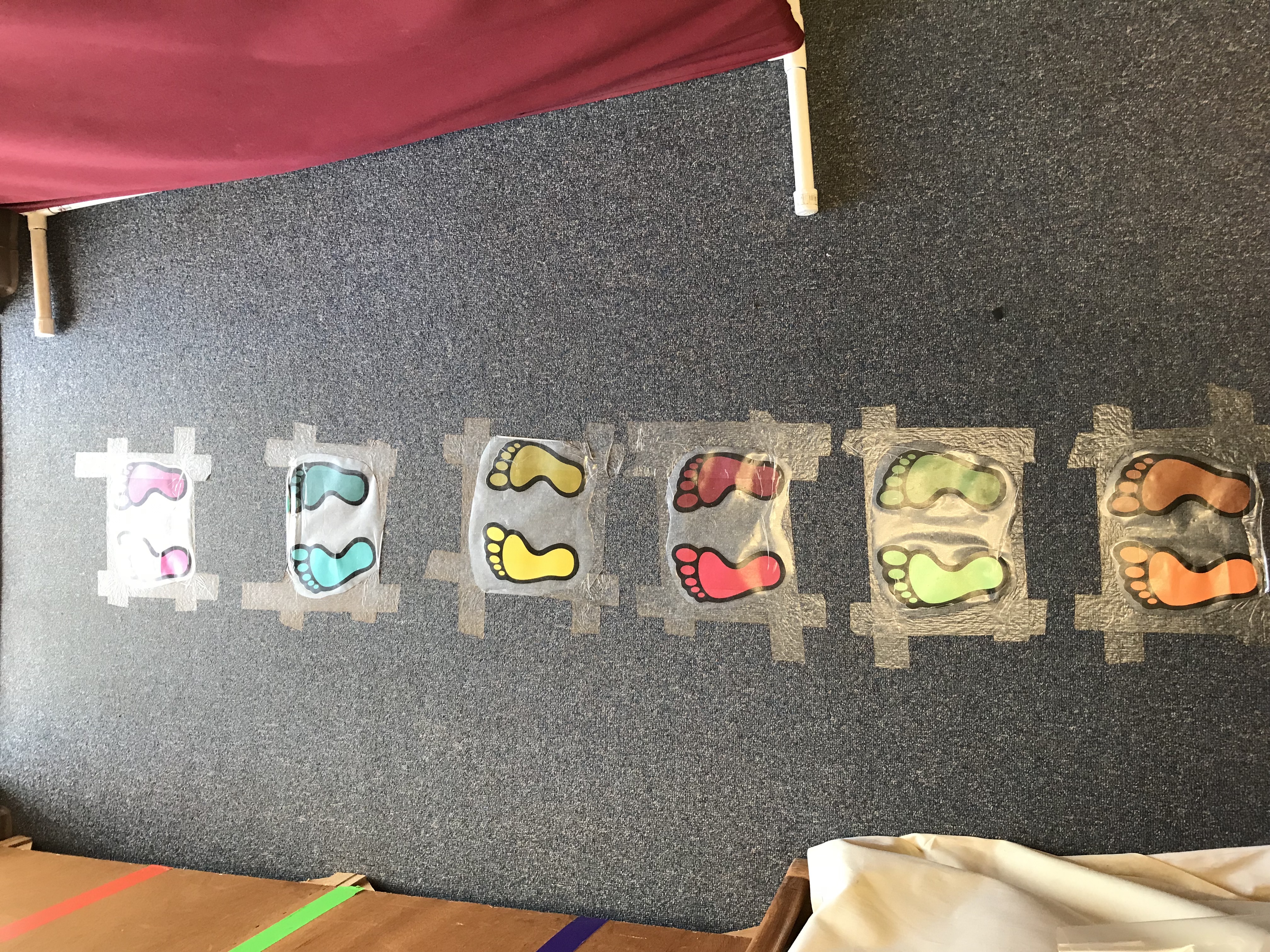 Laminated assorted colored footprints taped on carpet