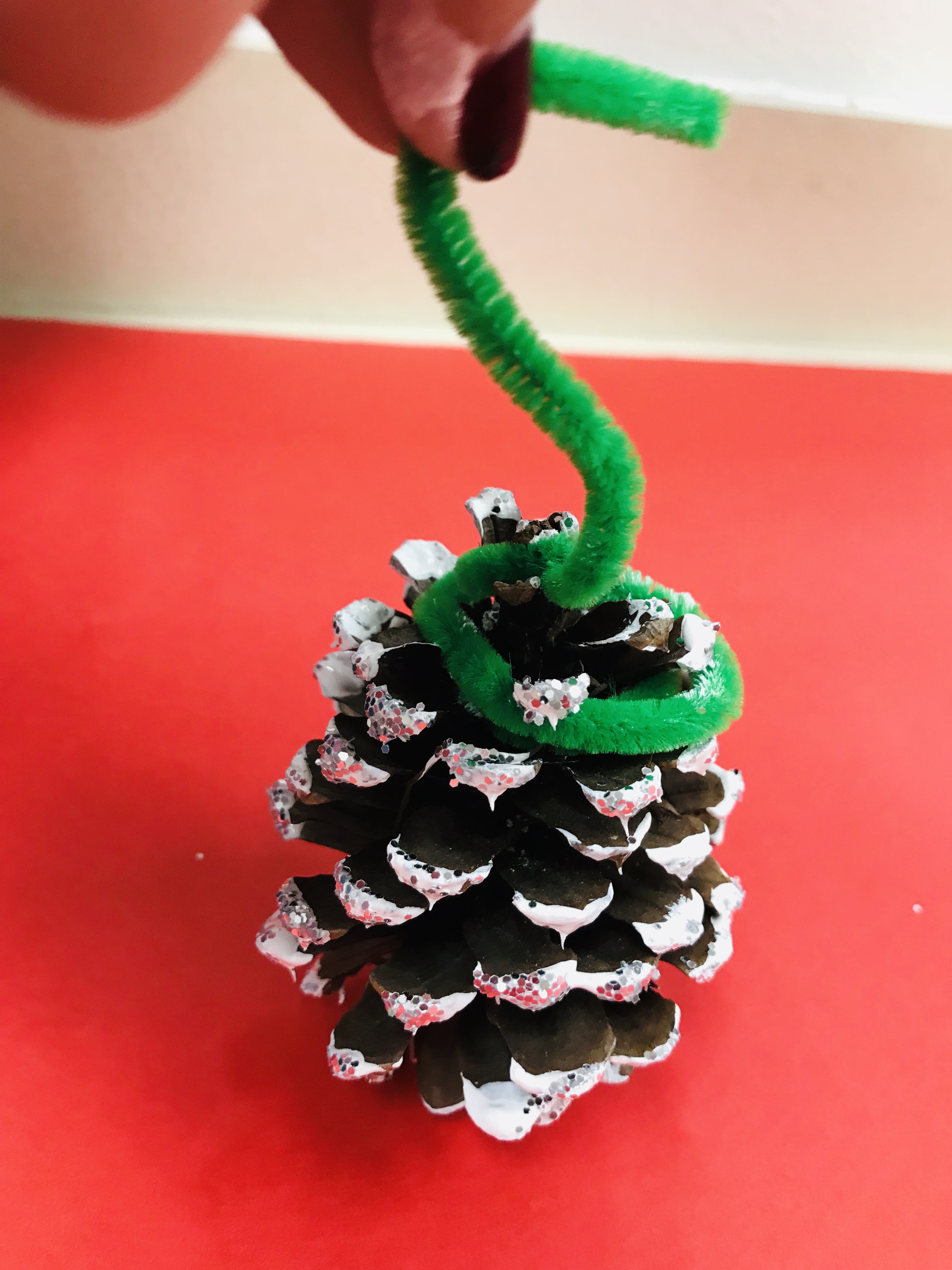 Glittered pine cones on green pipe cleaner stems
