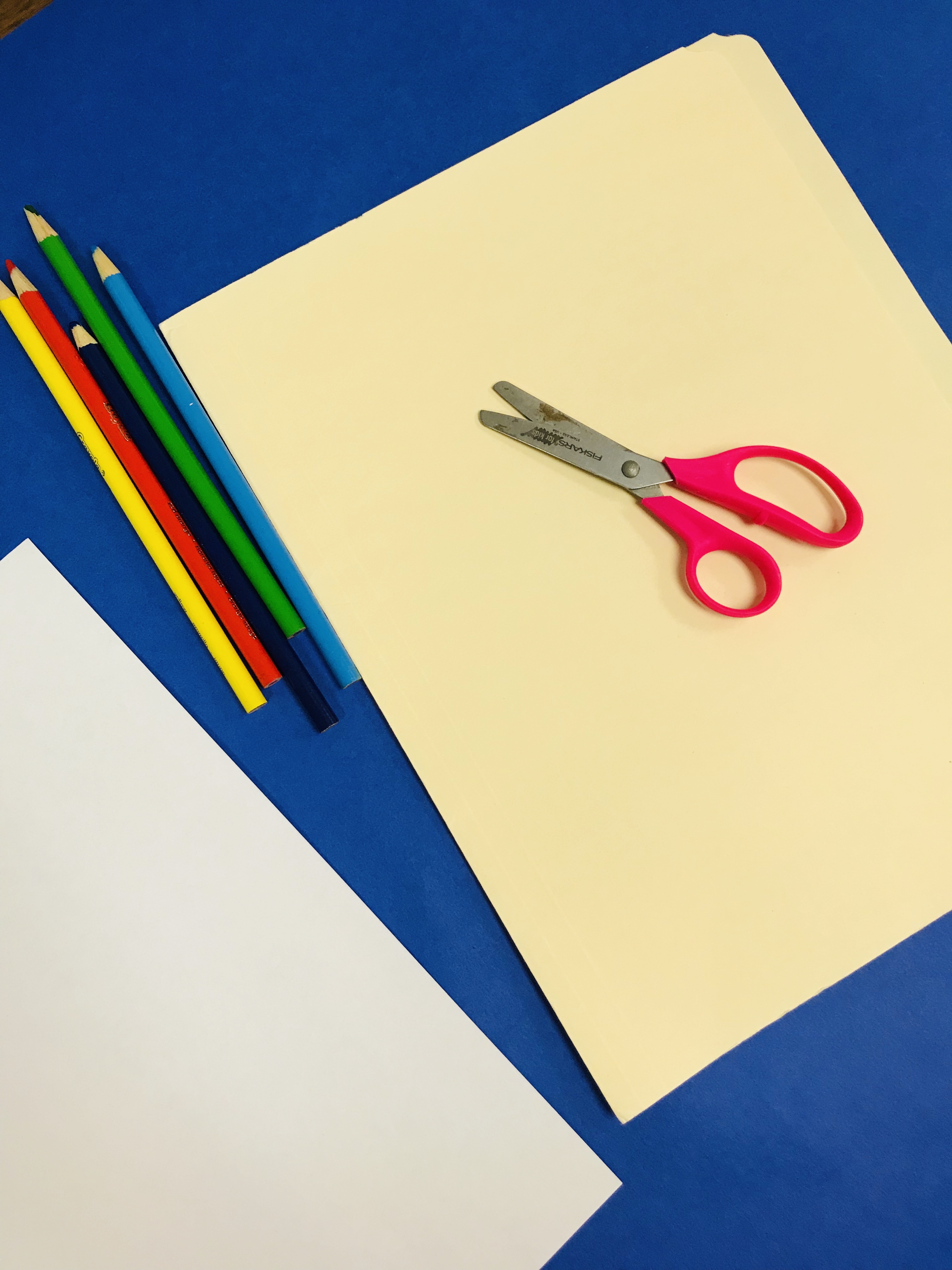 Folder, colored pencils and scissors